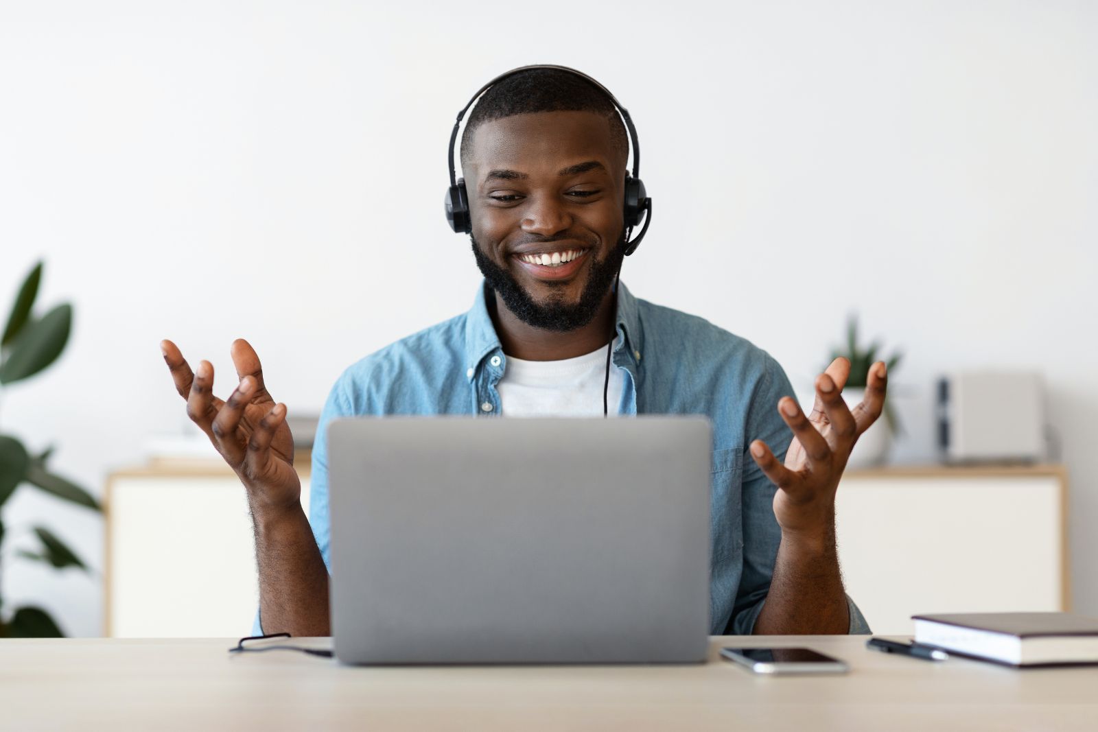 Adult wearing headphones while using a laptop at home